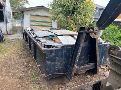 Large hooklift bin ready to be picked up an collected